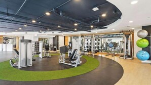 A modern gym with various exercise equipment, including weight machines and free weights. - Landing | Stunning 1BD, Courtyard, Gym (San Antonio)