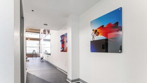 Un pasillo con una escalera que lleva a un área de gimnasio, una obra de arte en la pared y un marco de puerta.