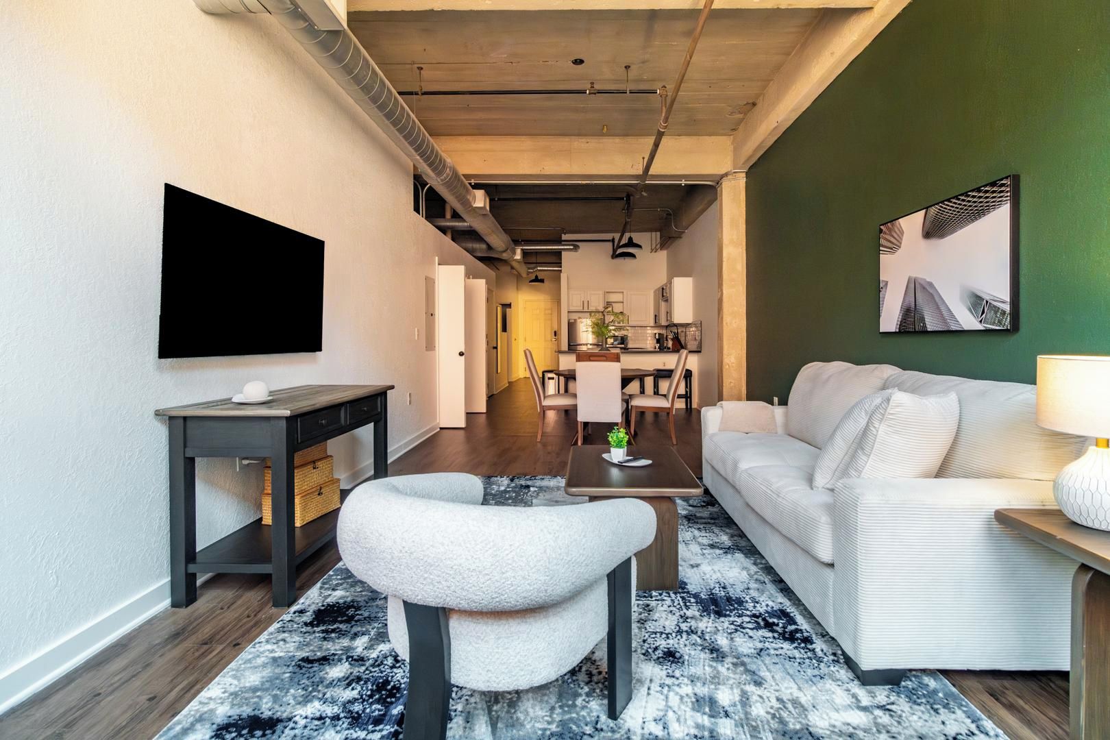 Un soggiorno moderno con un divano, un tavolino da caffè e una TV a parete.