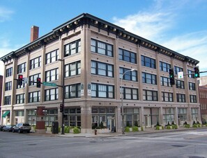 A multi-story building with a brick facade, large windows, and a corner location at an intersection.