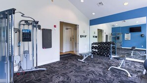 A gym with exercise equipment, a mirror, and a wall-mounted dumbbell rack. - Landing | Modern 2BD, Yoga Studio, Pool (Lakewood)