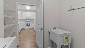 A kitchen with white cabinets, a microwave, and an oven. - 3-bedroom condo in beautiful Calabash golf course community (Calabash)