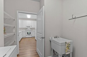 Eine Küche mit weißen Schränken, einer Mikrowelle und einem Backofen.