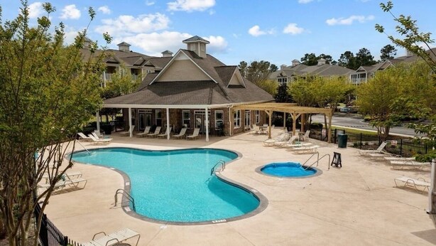 A swimming pool with lounge chairs and a covered seating area. - 3-bedroom condo in beautiful Calabash golf course community (Calabash)