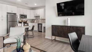 A modern kitchen with white cabinets, a stainless steel refrigerator, a microwave, and a dishwasher. - Landing | Modern 1BD in Kannapolis (Kannapolis)