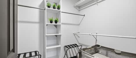 A compact room with a white shelving unit, a black metal rack, and a mesh safety barrier.