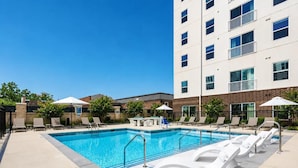 A rectangular swimming pool with a clear blue water surface, surrounded by lounge chairs and umbrellas. - Landing | Spectacular 1BD in Kannapolis (Kannapolis)