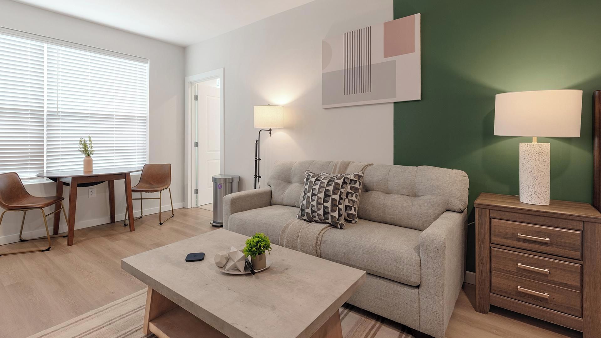 En moderne stue med sofa, sofabord og lampe.