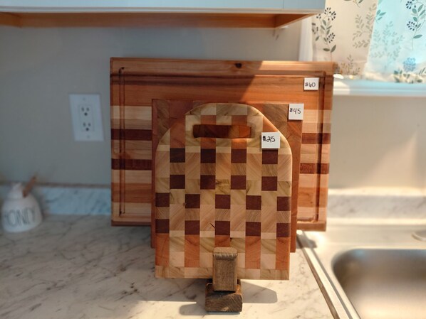 Un plan de travail de cuisine avec une planche à découper en bois et un porte-couteaux.
