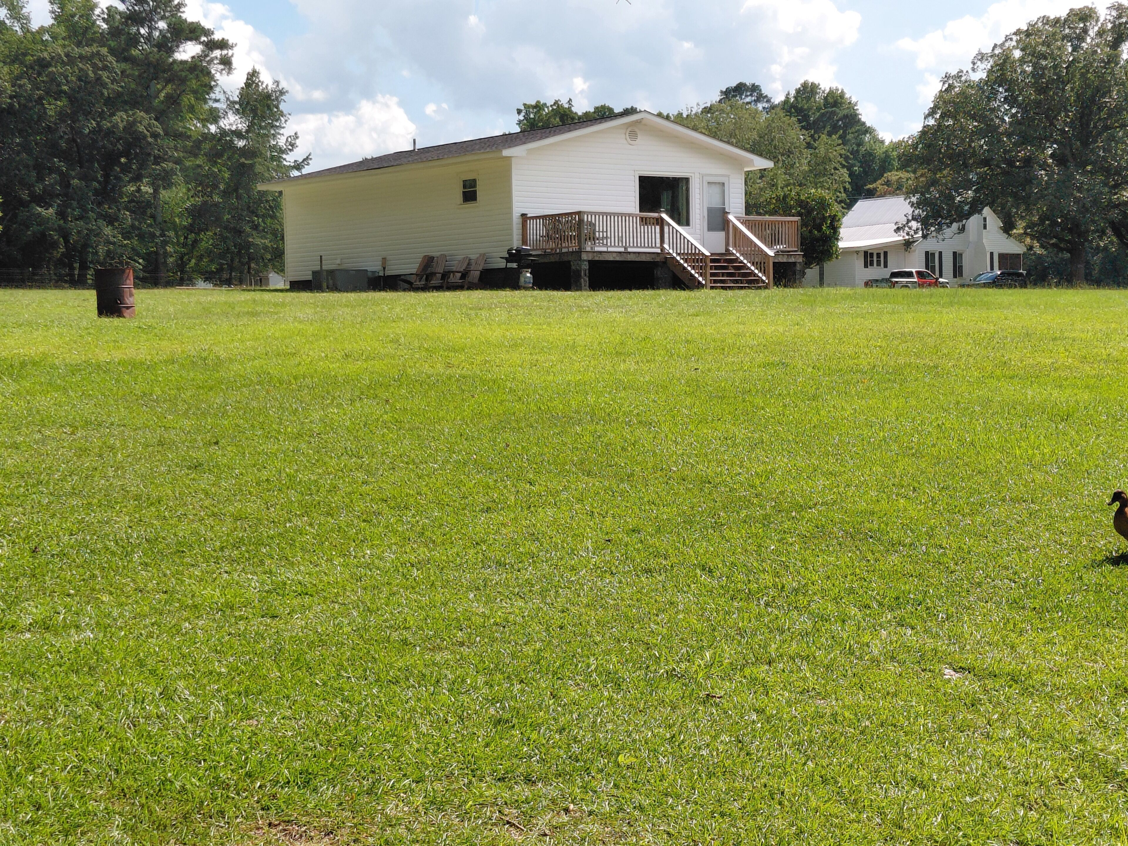 A single-story house with a front deck and a staircase leading to a covered porch.