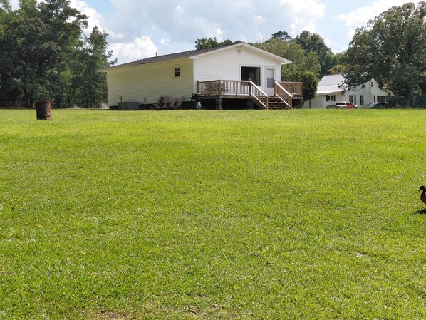 A single-story house with a front deck and a staircase leading to a covered porch.