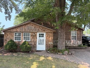 A single-story wooden house with a shingled exterior, a white front door, and a mailbox. - Charming 3-bedroom house in marvelous Township of Burtchville with AC (Township of Burtchville)