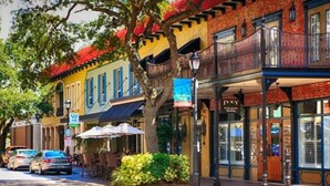 A street view with a row of colorful buildings, a tree, and parked cars. - King Studio · Rainfall Shower · Beach Gear (Bradenton)