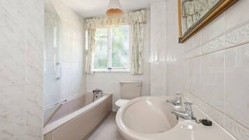 A bathroom with a bathtub, toilet, and sink.