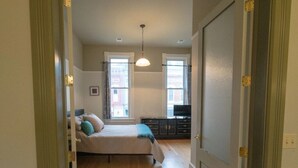 Un dormitorio con cama, cómoda y televisor.