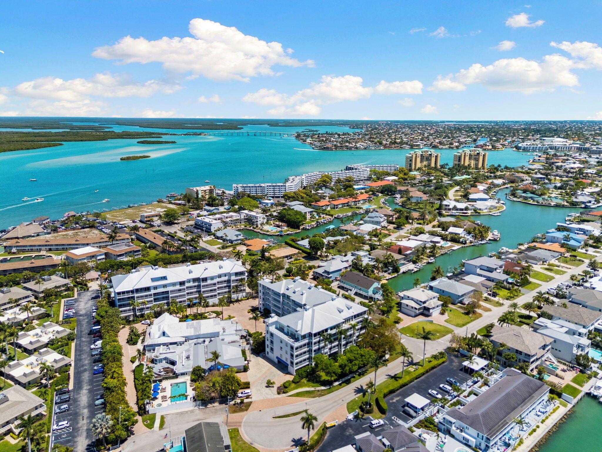An aerial view of a coastal town with buildings, roads, and a marina.