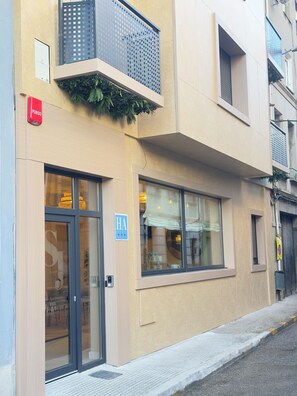 A building with a ground-floor entrance, a visible fire alarm, and a sign indicating a hotel. - SJ Puerta de Redes (Pola de Laviana)