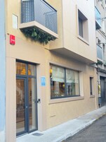 Un edificio con entrada a nivel de calle, detector de incendios visible y un cartel que indica un hotel.
