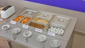 Een buffet met aangeduide gerechten, waaronder macaroni, chowder, bathure en gekookte eieren.