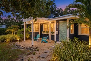 A house with a covered porch, two chairs, and a door marked with the number 125. - Heated Pool + Spa, Fenced Yard, Fire Pit, Sleeps 8, 15 Min to AMI (Bradenton)