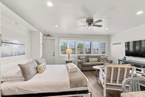A bedroom with a bed, a sofa, a TV, and a ceiling fan. - Suite Y'all | 2-Min Walk to Beach | Pet Friendly (Santa Rosa Beach)
