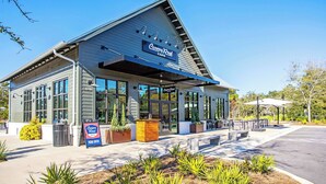 A Canopy Road Cafe with a modern design, large windows, outdoor seating, and a clear sky. - Suite Y'all | 2-Min Walk to Beach | Pet Friendly (Santa Rosa Beach)