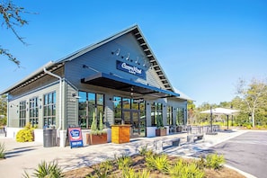 A Canopy Road Cafe with a modern design, large windows, outdoor seating, and a clear sky. - Suite Y'all | 2-Min Walk to Beach | Pet Friendly (Santa Rosa Beach)