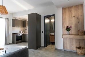 Una cucina moderna con forno integrato e zona pranzo con divano grigio.
