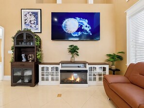 A living room with a fireplace, a television mounted above it, and a sofa. - Candy’s Garden Vacation House - Spacious 5-bedroom Las Vegas (Las Vegas)