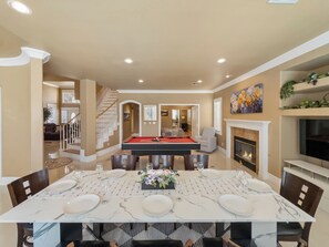 A dining area with a pool table, a fireplace, and a TV mounted on the wall. - Candy’s Garden Vacation House - Spacious 5-bedroom Las Vegas (Las Vegas)
