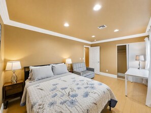 A bedroom with a bed, bedside tables, a dresser, and a closet. - Candy’s Garden Vacation House - Spacious 5-bedroom Las Vegas (Las Vegas)