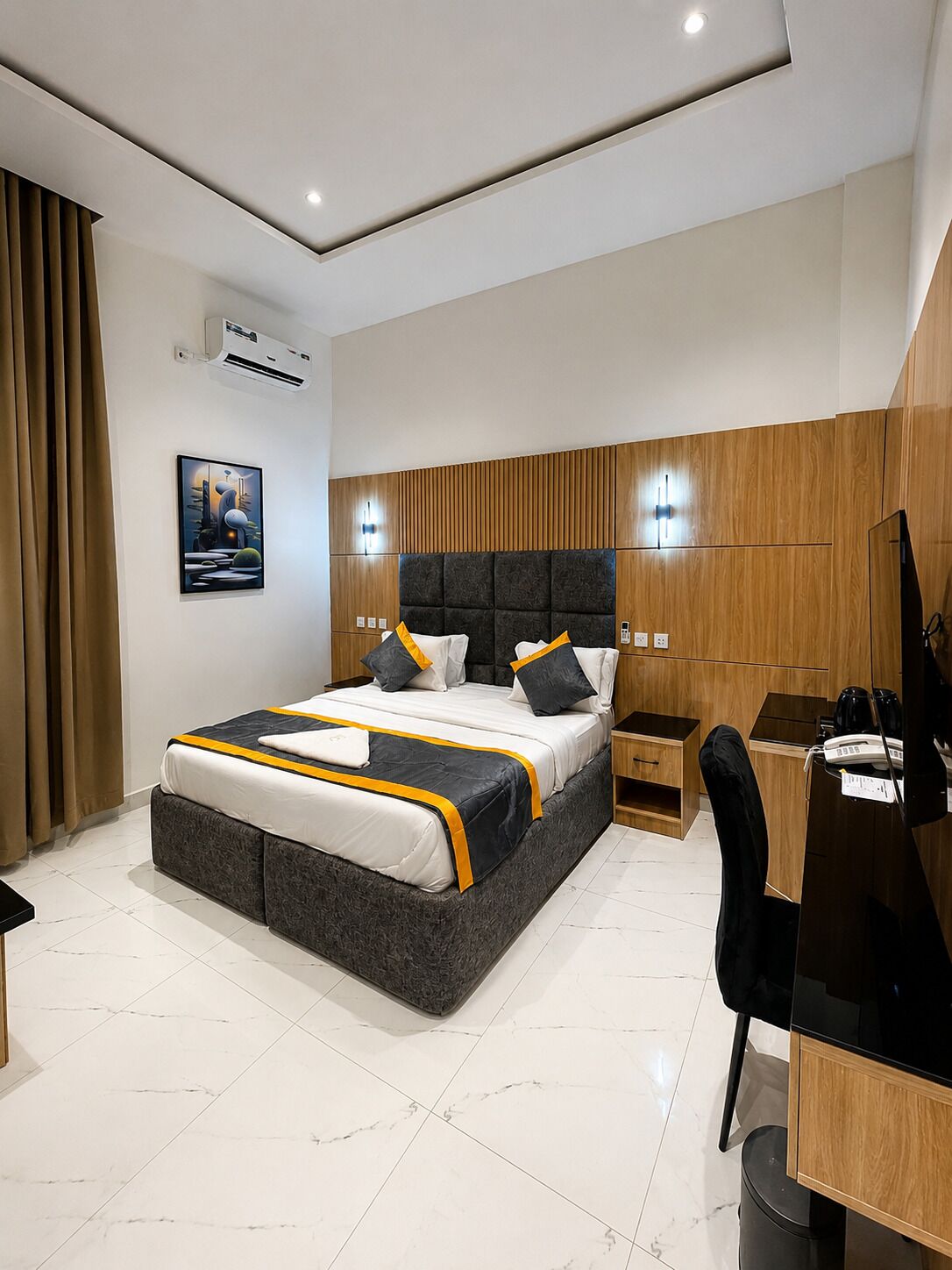 Un dormitorio moderno con una cama grande, un escritorio y una silla.