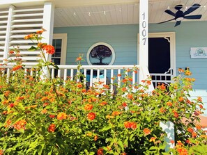 A porch with a white railing, a number sign, and a decorative tree mural. - Convenient Location in Town, Perfect for Two! (Beaufort)