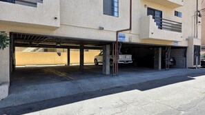A multi-level parking garage with concrete pillars, a covered area, and a vehicle inside. - Pico-Robertson 2BR/2BA • King Bed • Free Parking • Near Rodeo Dr (Beverly Hills)