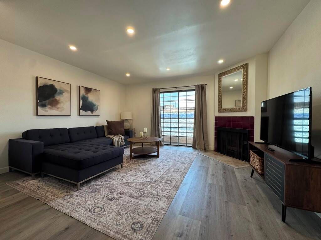 A modern living room with a sofa, a television, and a fireplace.