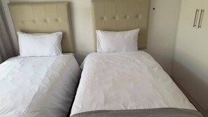 A hotel room with two beds, each with a headboard and white bedding. - Superb 2-bedroom apartment in adorable Windhoek neighborhood (Windhoek)