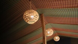 An interior with a high ceiling, patterned walls, and a central table with baskets. - Ferme Dar Charach (Tarmigt)