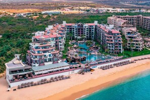 Ein Resort mit mehreren Gebäuden, einem Poolbereich im Zentrum und einem Strand.