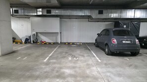 A parking garage with a Fiat car parked in a spot marked 48. - Designer Apartment in Rosebery (Rosebery)