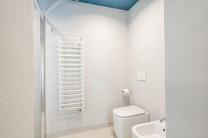 A bathroom with a white toilet, a white sink, and a white towel rack. - Loggiato Verga XVIIICent. Suite Bardiglio by Bed&Bros (SIRACUSA)