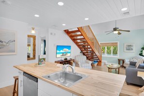 A modern kitchen with a built-in dishwasher and a wooden countertop. - Sea Haven | A Charming Florida Keys Cottage Near Sombrero Beach (Marathon)