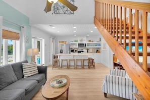 A modern interior with a living area, kitchen, and staircase. - Sea Haven | A Charming Florida Keys Cottage Near Sombrero Beach (Marathon)