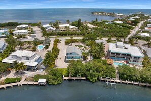 A coastal residential area with houses, a swimming pool, and a dock. - Sea Haven | A Charming Florida Keys Cottage Near Sombrero Beach (Marathon)