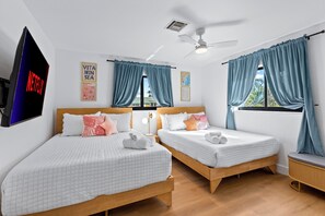 A hotel room with two beds, a ceiling fan, a TV, and a window with curtains. - Quiet Oasis-Heated Pool •Fire Pit •Outdoor Games (Fort Lauderdale)