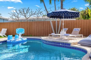 A swimming pool with lounge chairs and an inflatable pool float. - Quiet Oasis-Heated Pool •Fire Pit •Outdoor Games (Fort Lauderdale)