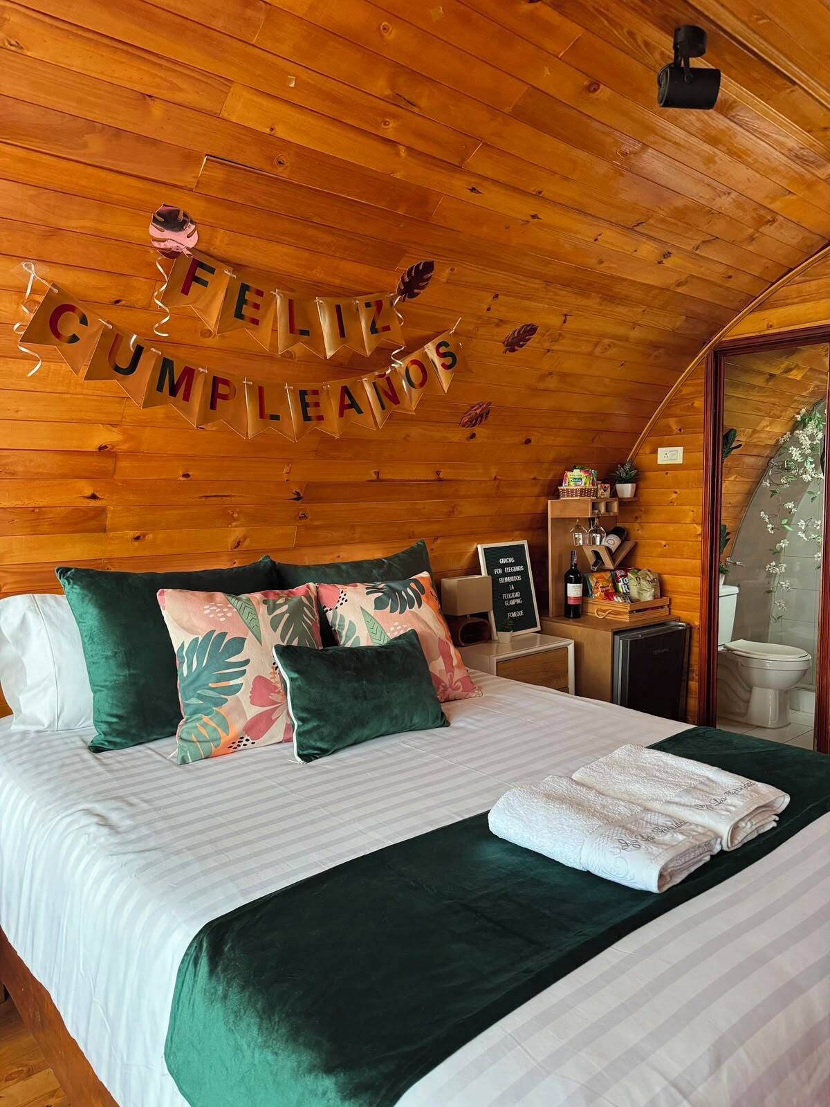 A cozy room with a bed, pillows, a nightstand, and a wall decoration.