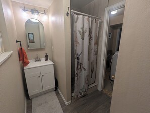 A bathroom with a sink, mirror, towel rack, and shower curtain. - The Briargate Bungalow only 5 Mins to USAFA with Pikes Peak Views (Colorado Springs)