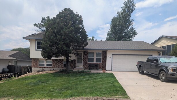 A residential house with a garage, a driveway, and a parked pickup truck. - The Briargate Bungalow only 5 Mins to USAFA with Pikes Peak Views (Colorado Springs)