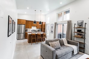 A modern kitchen with wooden cabinets, stainless steel appliances, and a central island with bar stools.