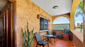 A balcony with a tiled floor, a table, two chairs, and potted plants. - Beautiful Apartment with amazing views ! A hidden gem! (San José del Cabo)